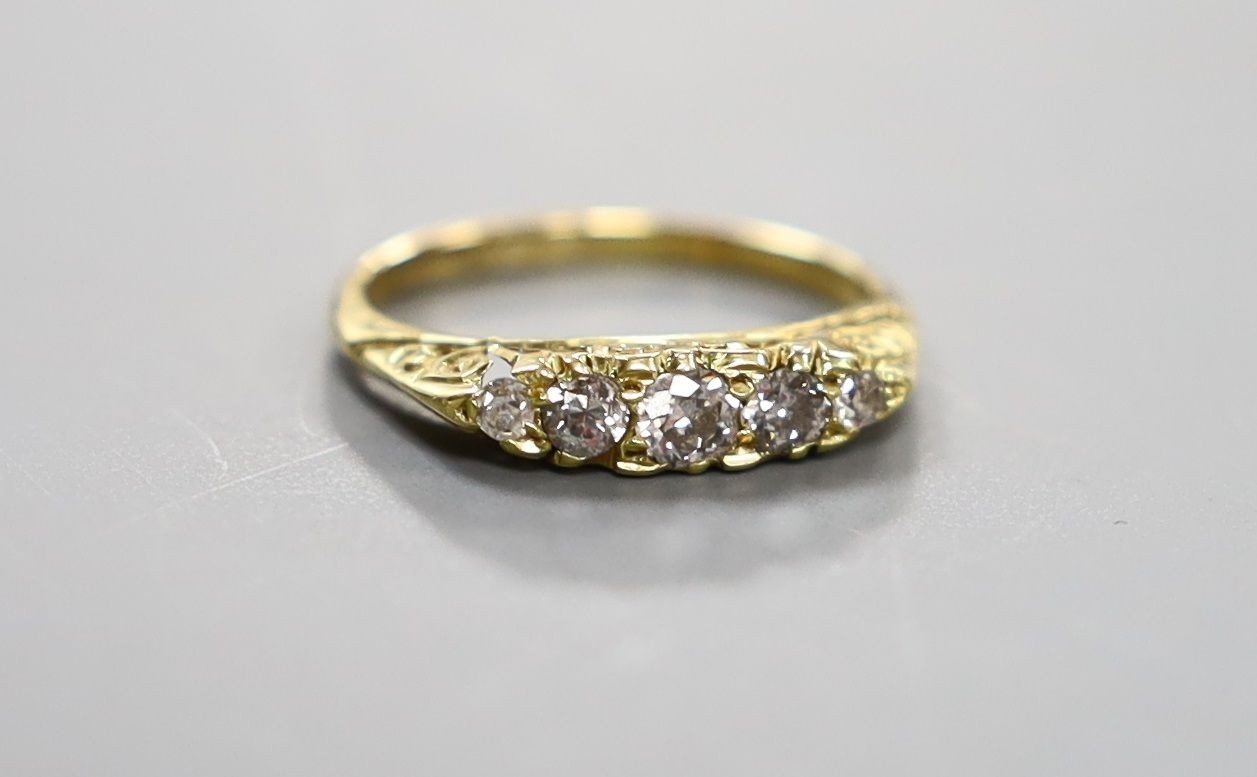 An early 20th century 19ct gold and graduated five stone diamond set half hoop ring, size G, gross weight 2.8 grams.
